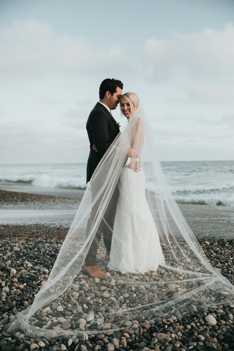 Bride and groom by the sea at sunset